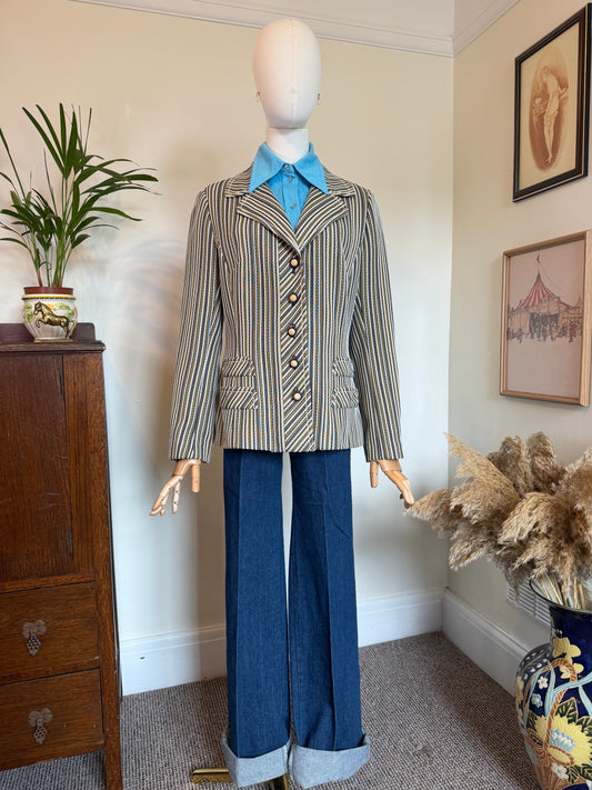A vintage striped blazer with notched lapels and button front, styled on a mannequin with a light blue shirt and blue jeans in an indoor room setting.