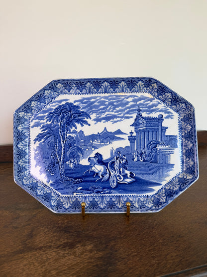 Early 20th century Cauldon England blue and white transferware octagonal serving platter featuring a classical landscape scene on a wooden sideboard.