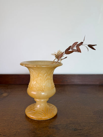 1960s honey coloured carved alabaster bud vase with engraved leaf design on a pedestal base.