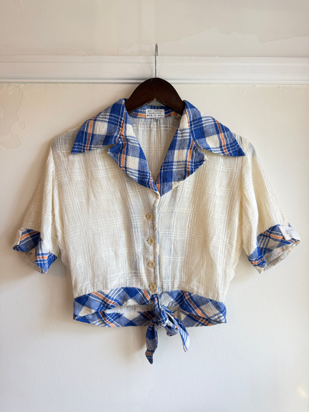 Vintage 1970s cream cotton blouse with a blue and rust tartan oversized collar, turned-up short sleeves, button front and matching tie-front hem.