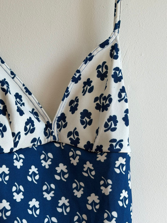 
Vintage blue and white floral one-piece swimsuit with adjustable straps and colour block design.