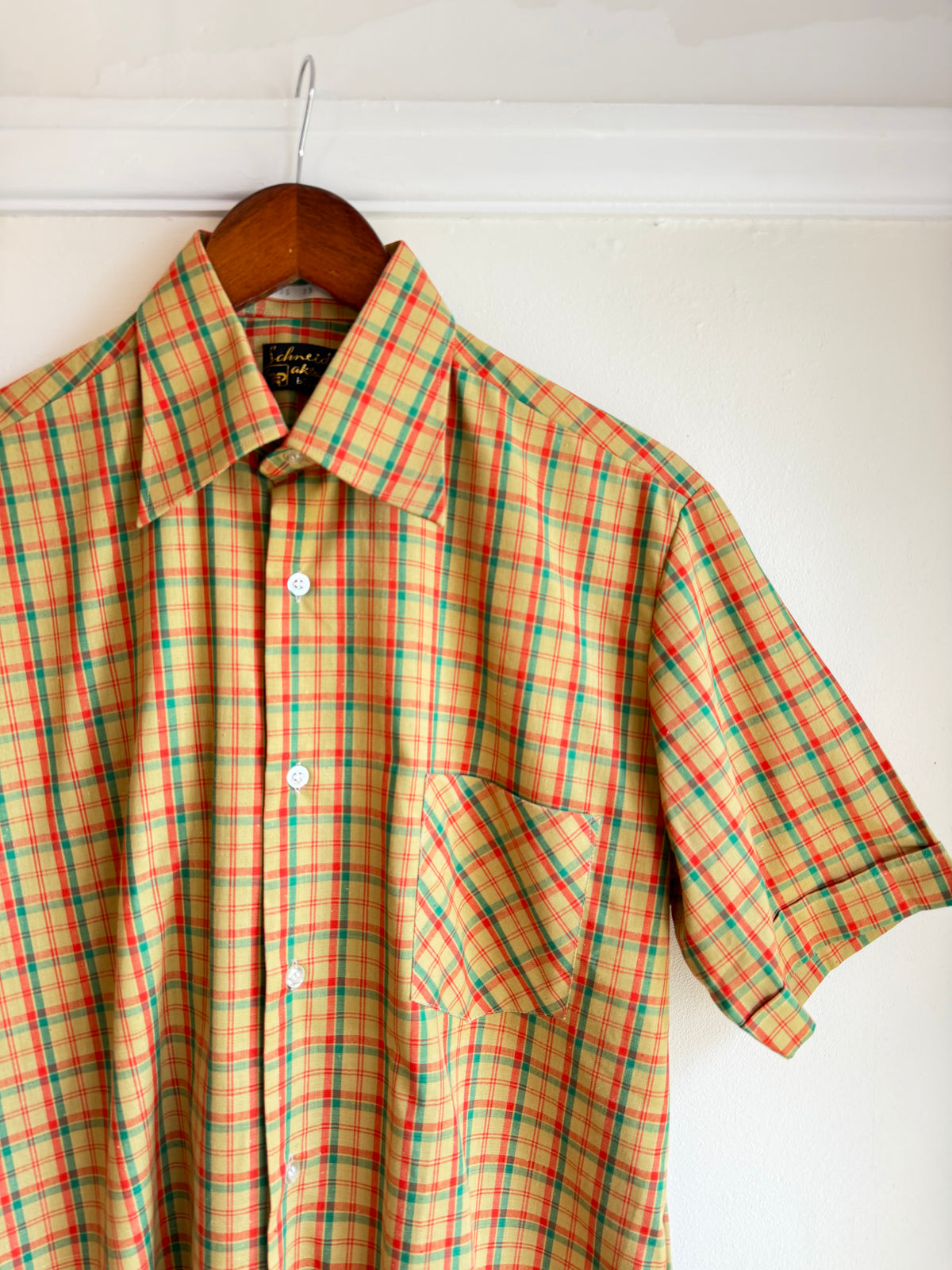 Vintage 1970s men's short-sleeve checked shirt in yellow with red and green tartan-style stripes, pointed collar, button front and single chest pocket.