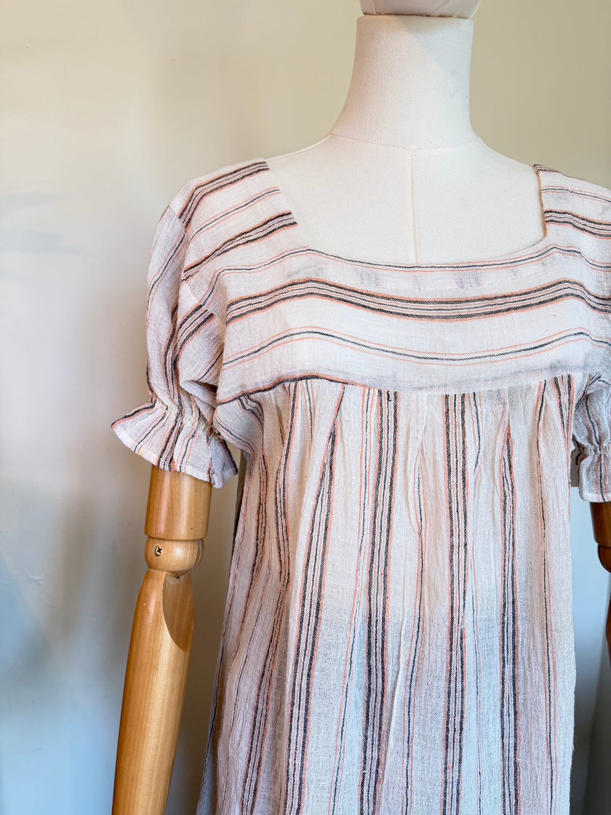 Vintage 1970s cotton smock top in blush pink, charcoal and white stripes, featuring a square neckline, gathered body and short puff sleeves with frilled cuffs.