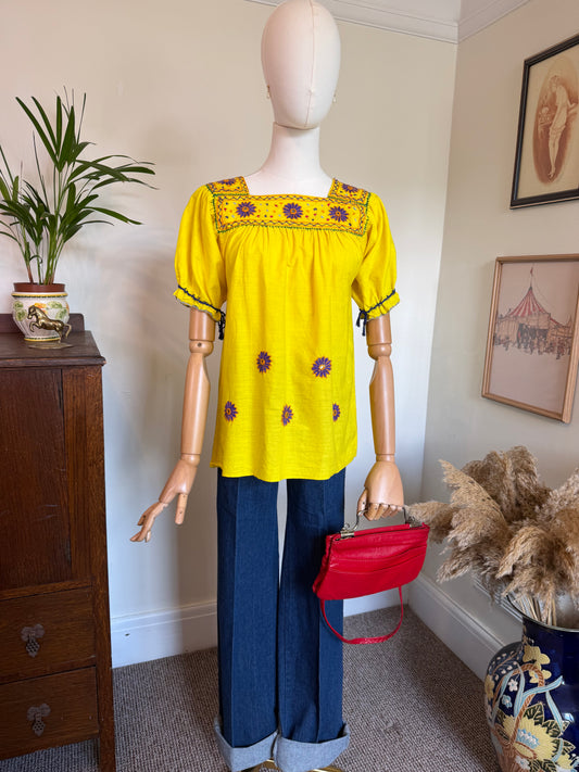 Vintage 1970s yellow embroidered floral smock top with colourful folk-inspired embroidery, square neckline, gathered bust and short puff sleeves.