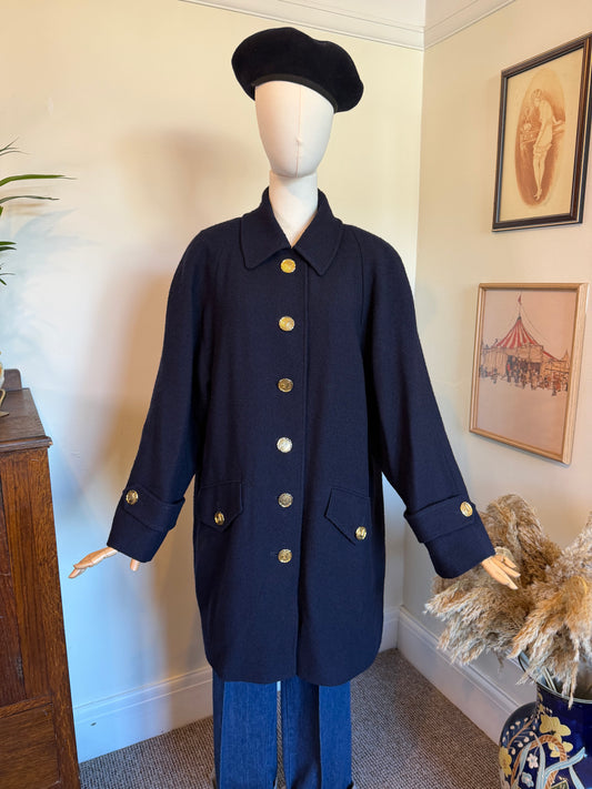 Vintage Jaeger navy blue pure wool coat made in Great Britain, featuring gold-tone buttons, a classic collar, front flap pockets and a full navy lining.