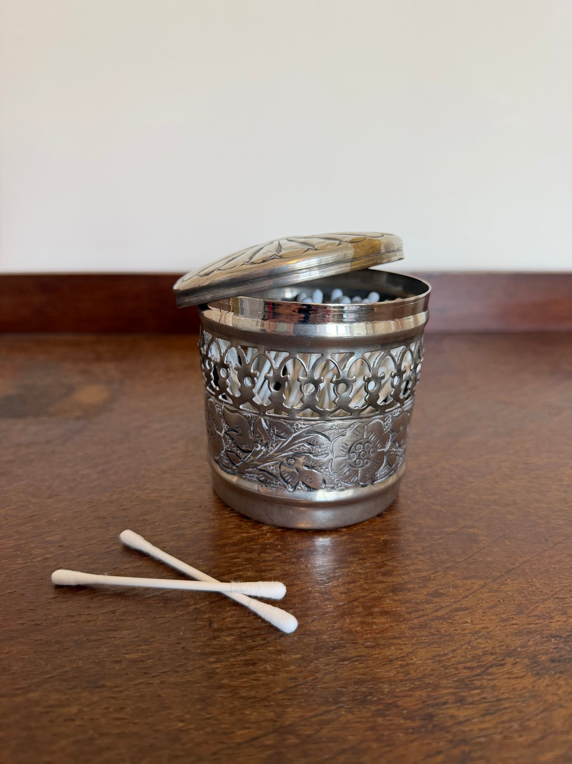 Alt Text

Vintage silver plated cotton bud holder with ornate pierced floral decoration and domed lid displayed open and closed.