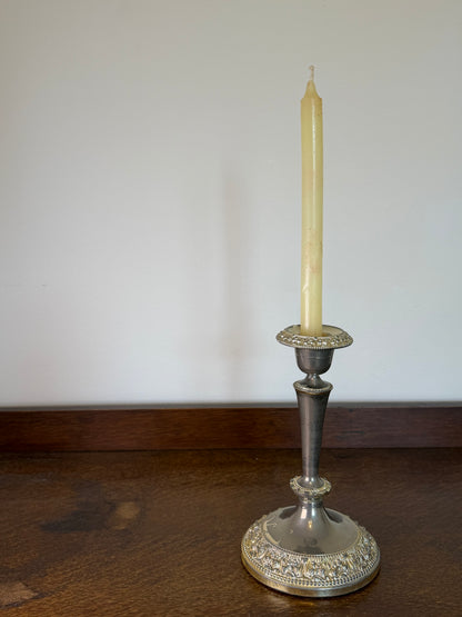 Vintage English silver plated candlestick with ornate embossed detailing holding a cream dinner candle.