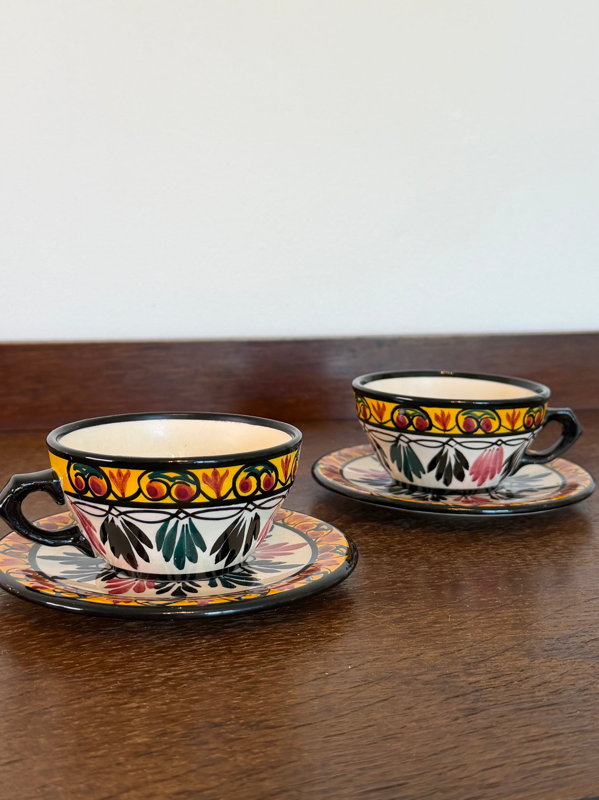 Pair of vintage French hand-decorated tea cups and matching saucers dated 1959 with colourful folk-art floral decoration.